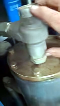 Hand on large metal service valve atop tank (SKU ask)