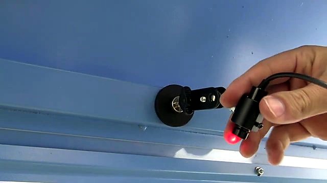 Hand holding black crosshair laser emitter (SKU ask)