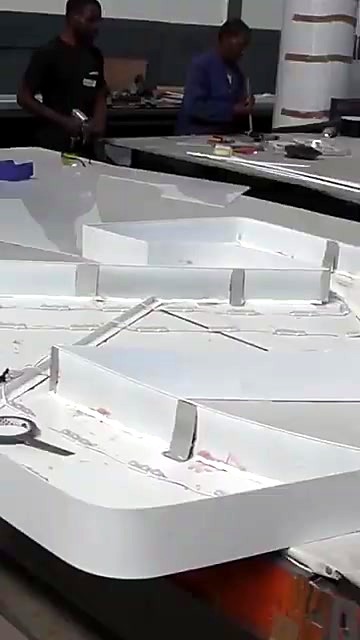 White 3D channel letter assembly on bench (SKU ask)