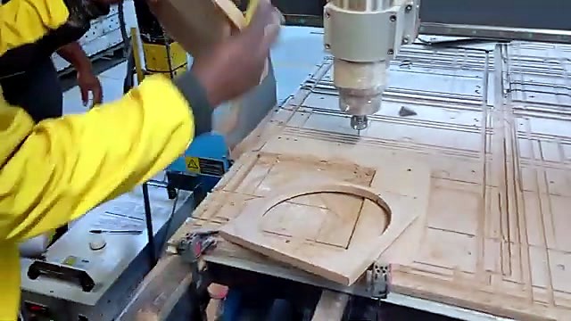 Worker lifts finished MDF square-with-circle (SKU ask)