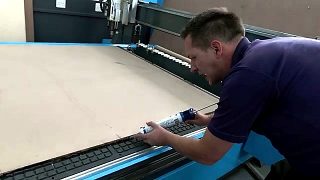 Tech applying sealant tube on EasyRoute vacuum bed edge (SKU ask)