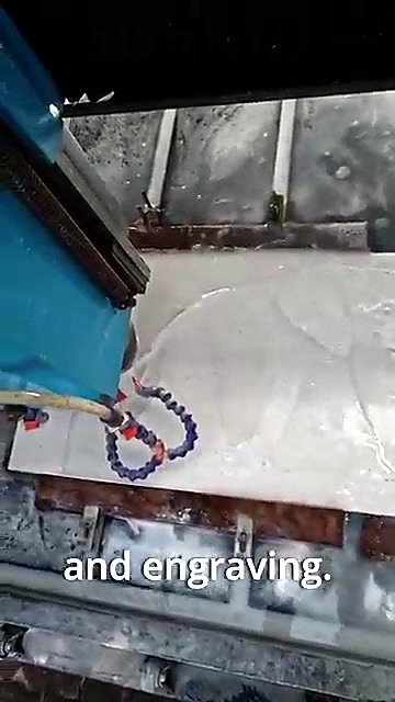 Stone router spindle with blue coolant hoses engraving the marble slab