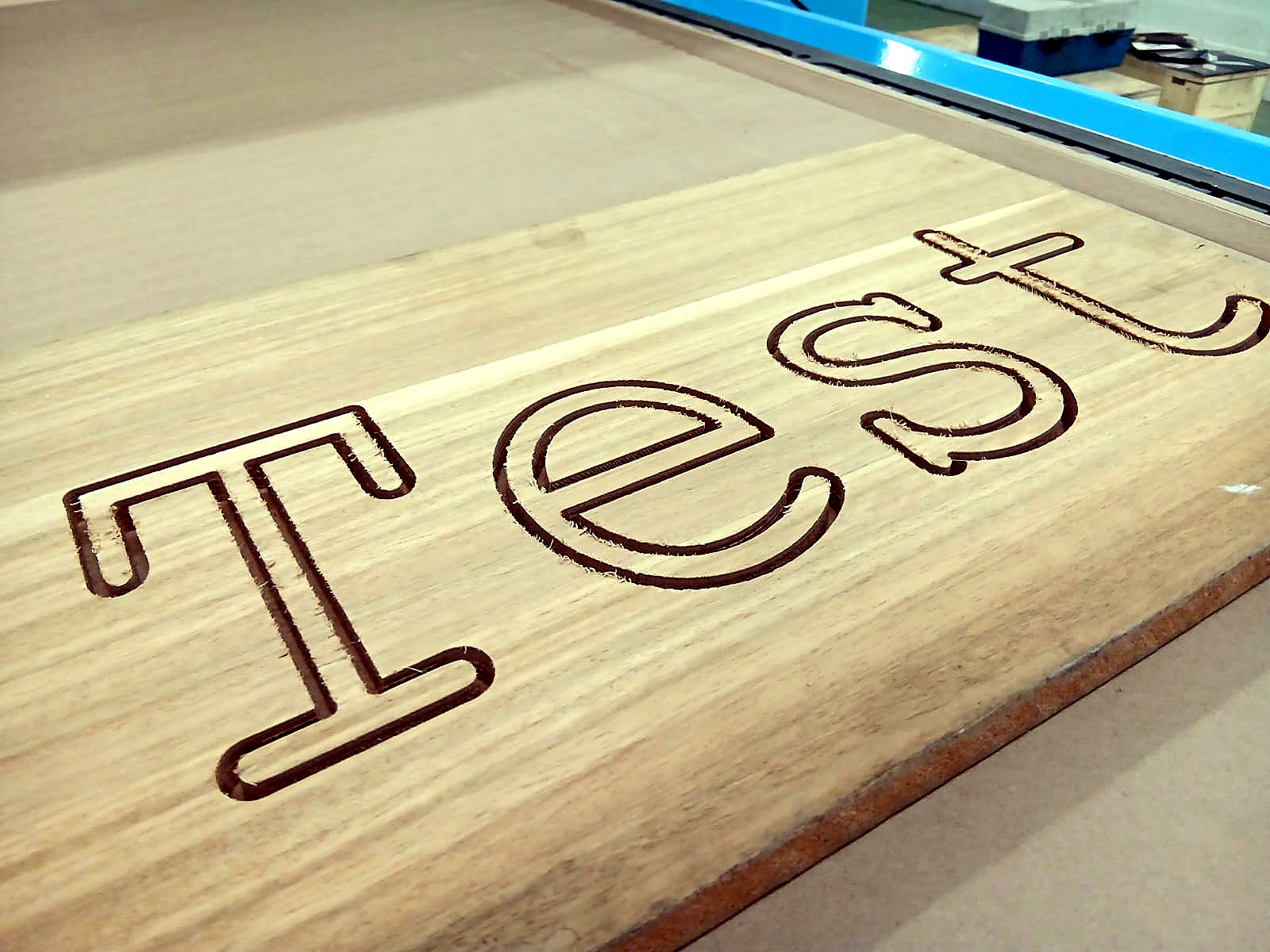 R-1325K/90L EasyRouter ATC: 'Test' outline lettering routed into timber plank on vacuum bed (staff still)