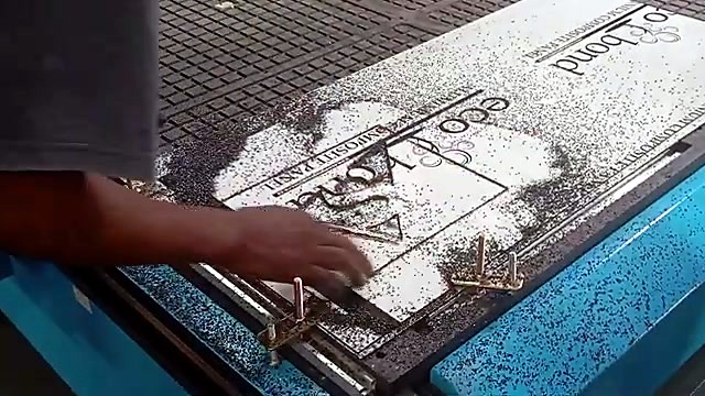 Hands brush swarf revealing engraved logo (SKU ask)