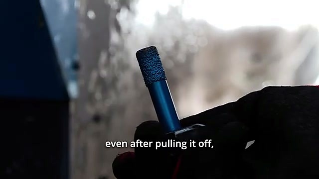 Blue stone router bit held in hand after cutting