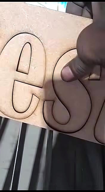 Hand lifting laser-cut letters from sheet (SKU ask)
