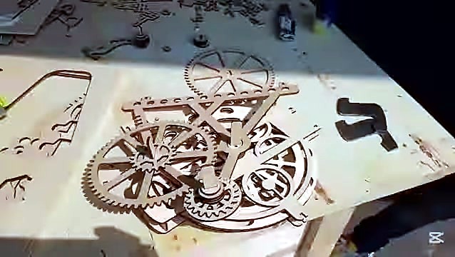 Laser-cut wooden gears and parts laid out (SKU ask)
