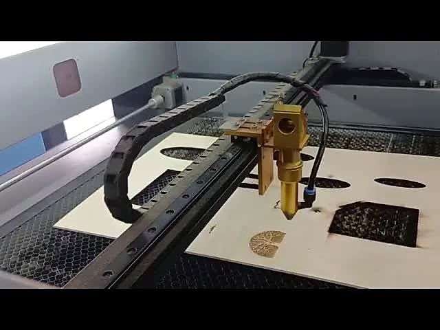 LC-6040L/80P CO2 laser head over a basswood sheet with cut-out holes