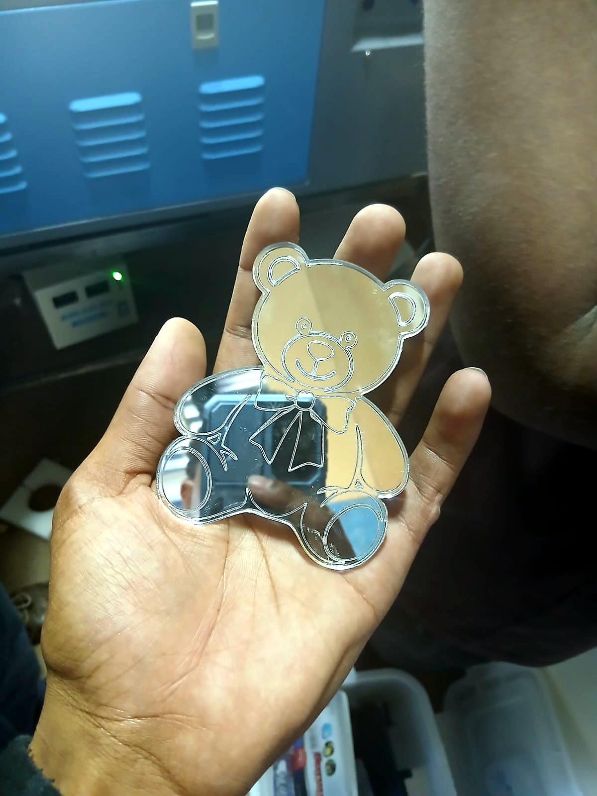 LC-6040L/80P TruCUT result: mirrored-acrylic teddy-bear cut/engrave held in hand (staff still)