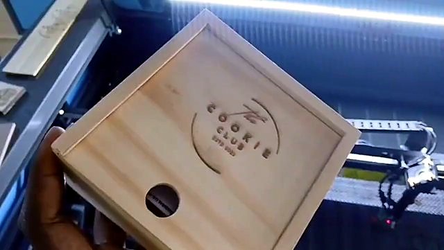 Hand holding engraved Cookie Club wood lid (SKU ask)