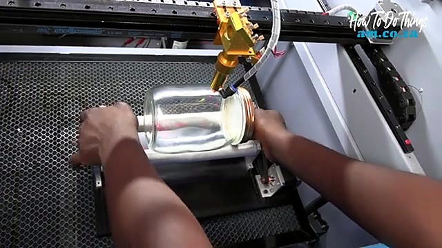 Glass jar mounted on rotary rollers under nozzle (SKU ask)