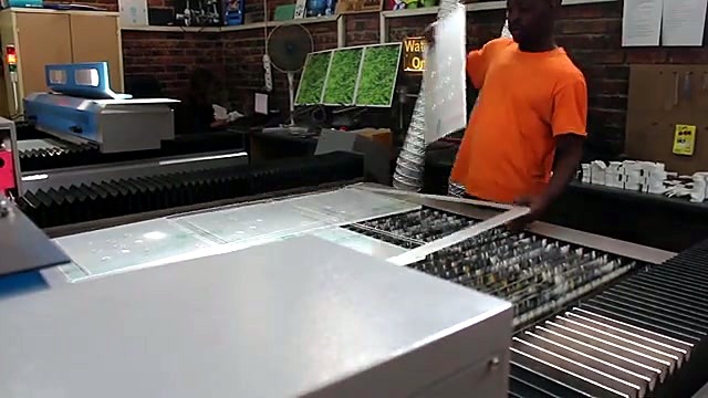 Operator lifting acrylic sheet from TruCUT slat bed (SKU ask)