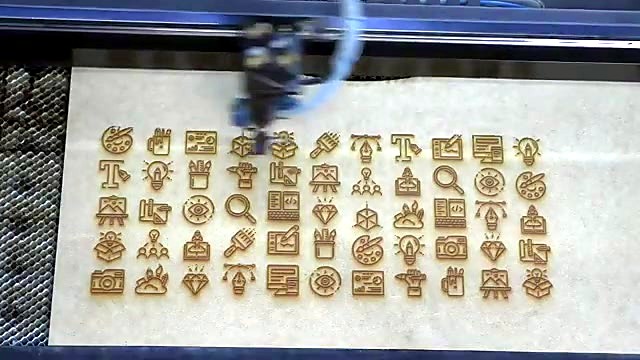 Dense icon grid engraved on wood desk-station top (SKU ask)