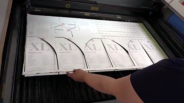 Hands extracting cut Perspex parts from honeycomb bed (SKU ask)