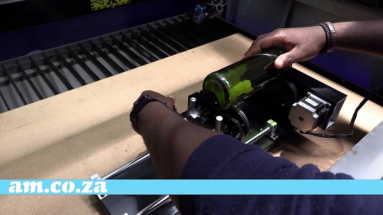 Green bottle placed on surface-drive rollers (SKU ask)