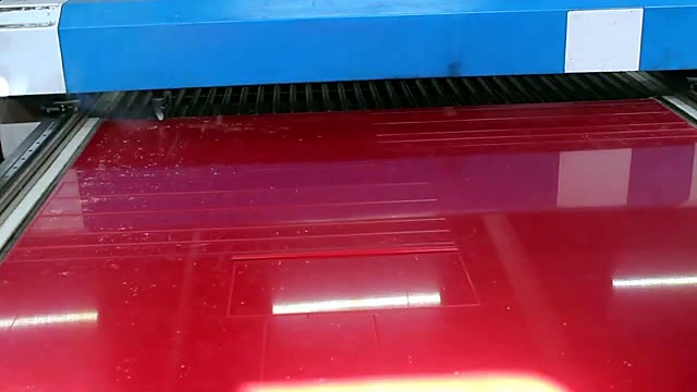 Red sheet with cut outlines on knife-slat bed (SKU ask)