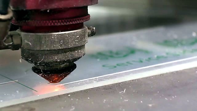 Orange laser glow cutting clear acrylic under red head (SKU ask)