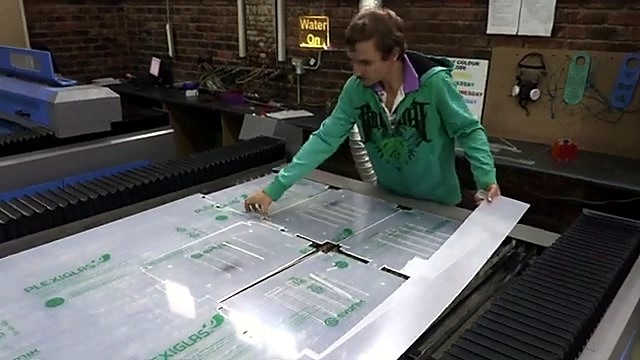 Operator handling cut acrylic sheets at TruCUT flatbed (SKU ask)