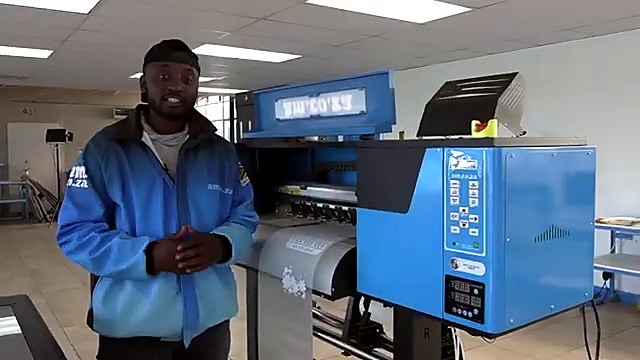 AM.CO.ZA presenter beside blue roll DTF printer (SKU ask)