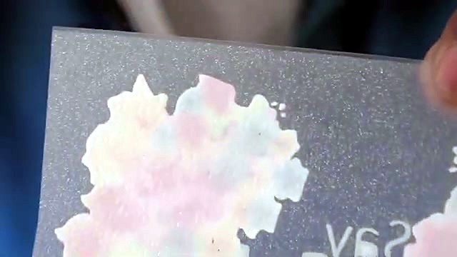 Hands holding colourful glitter DTF film (SKU ask)