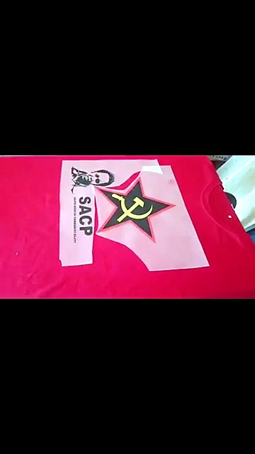 DTF film transfer with a star logo laid on a red T-shirt before pressing