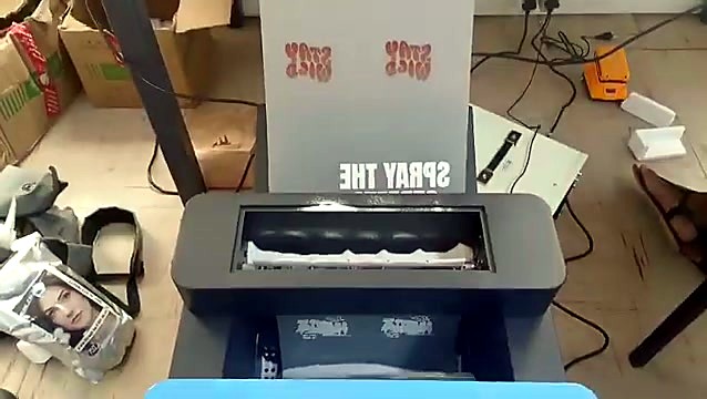 Printed DTF film feeding into the powder unit