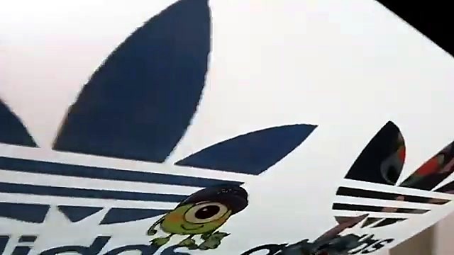White Adidas trefoil + green character on film (SKU ask)