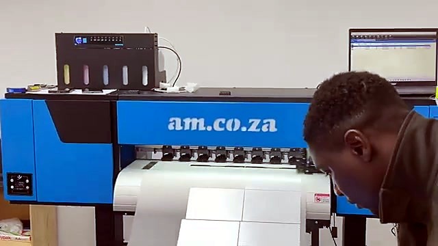Operator inspects print near am.co.za branded panel (SKU ask)