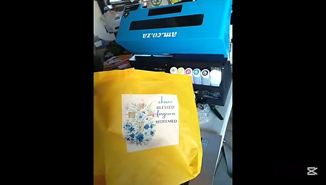 Floral transfer on yellow tote; A3 printer behind (SKU ask)