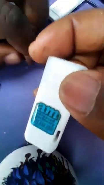 Hand holding white USB with teal am.co.za sticker applied (SKU ask)