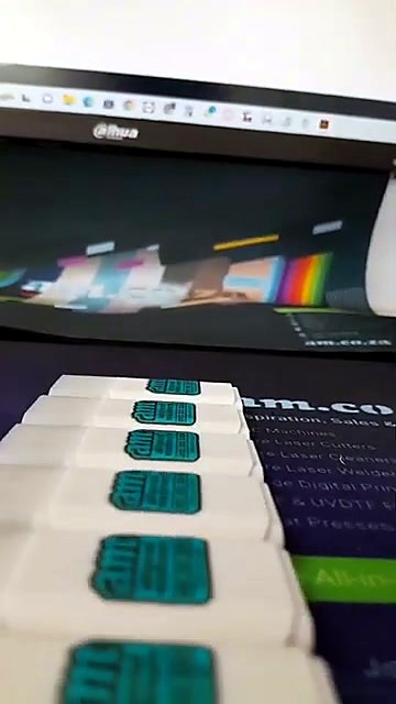 Row of finished white am.co.za branded USB drives (SKU ask)