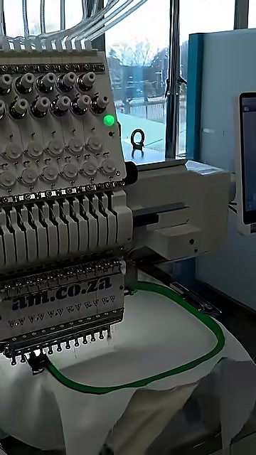 Thread-feed tubes into tensioners; green status LED (SKU ask)