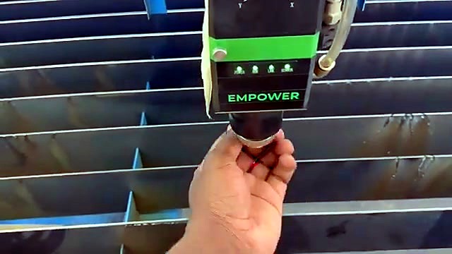 EMPOWER fiber laser cutting head positioned over the slatted cutting bed of the RayCUT Lite