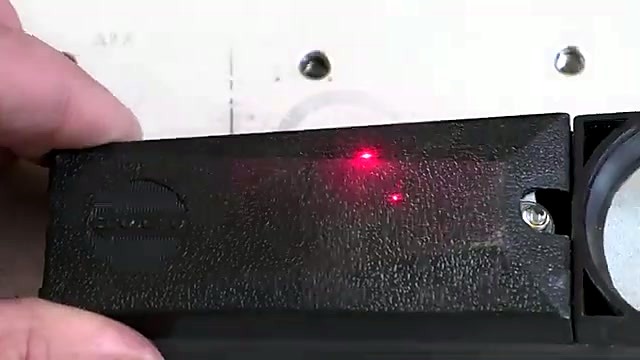 Hand holding ABS part with red focus dot (SKU ask)