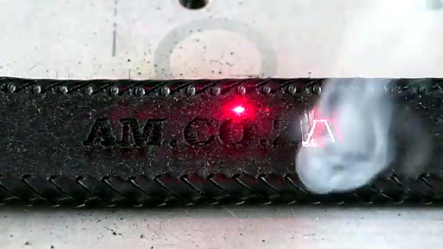 Red-dot fiber engrave AM.CO.ZA into leather with smoke (SKU ask)