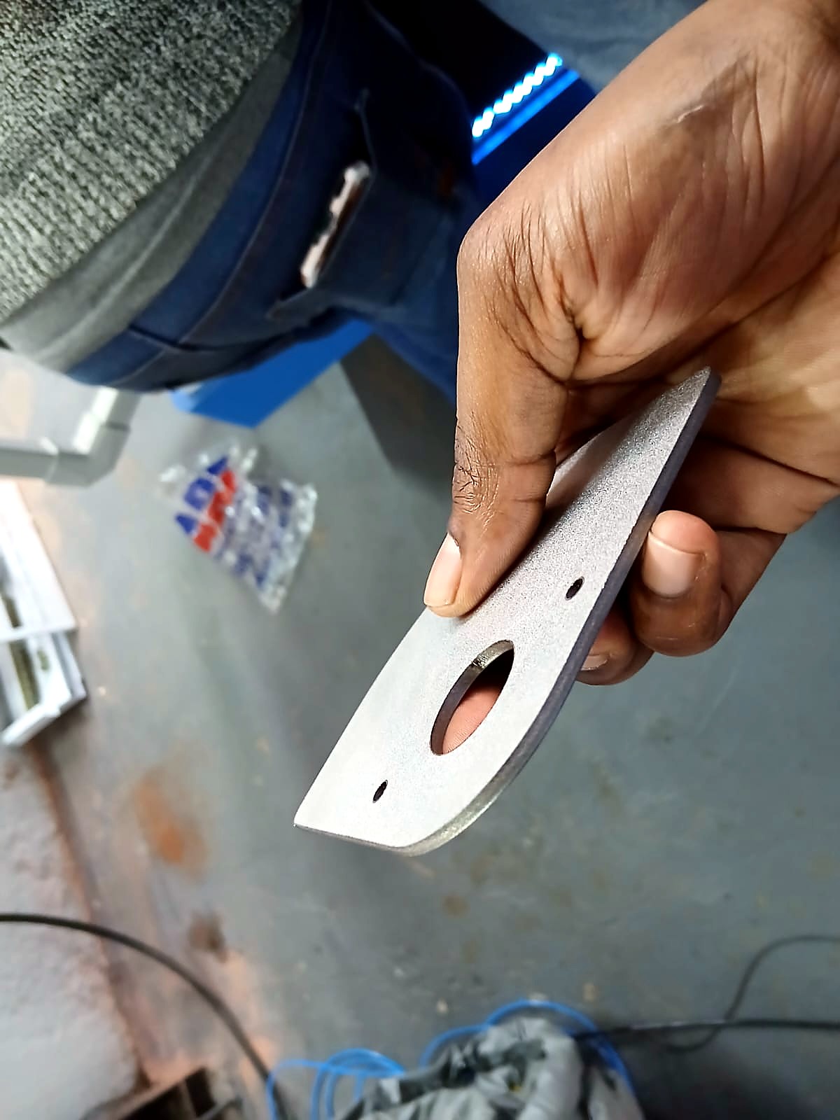 LF-2040/12000 RayCUT: hand-held metal cut sample (oval + two holes) with blue LED machine panel (April product still)