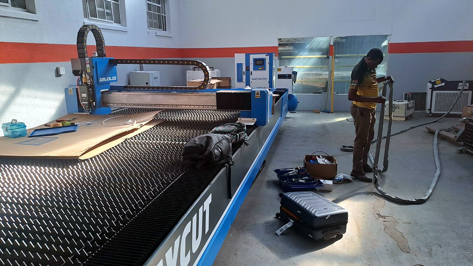 LF-2040/12000 RayCUT: workshop overview of bed cutter with technician (yellow polo) (April product still)