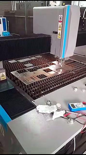 Fibre cutting head over rectangular metal cutouts on serrated bed (SKU ask)