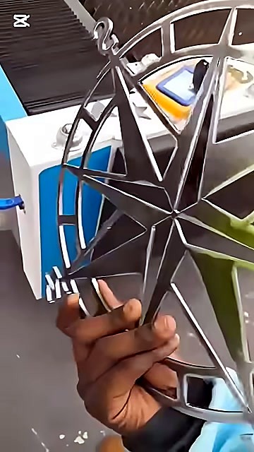 Hand holding finished metal compass rose (SKU ask)