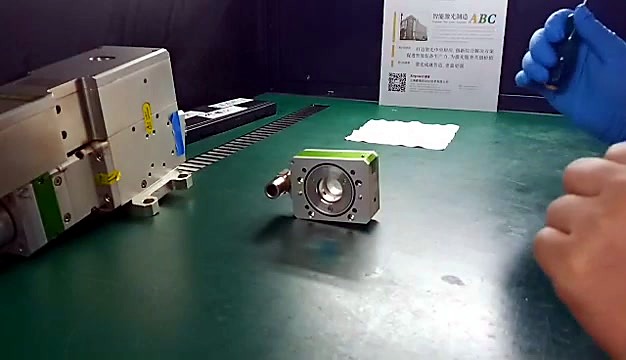 Lens housing on bench; RayTools doc behind (SKU ask)