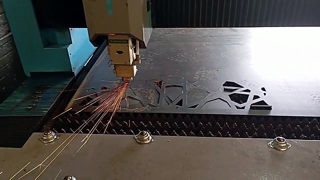 Laser head sparks cutting geometric lattice in steel (SKU ask)