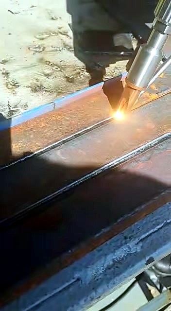 RustOFF-family handheld fibre: copper nozzle glow on rusted bars (SKU ask)