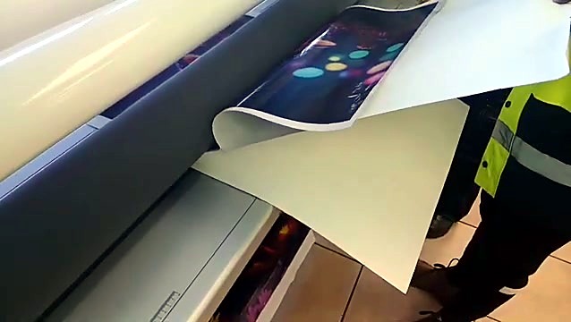 Operator peeling laminated print from roll stack (SKU ask)