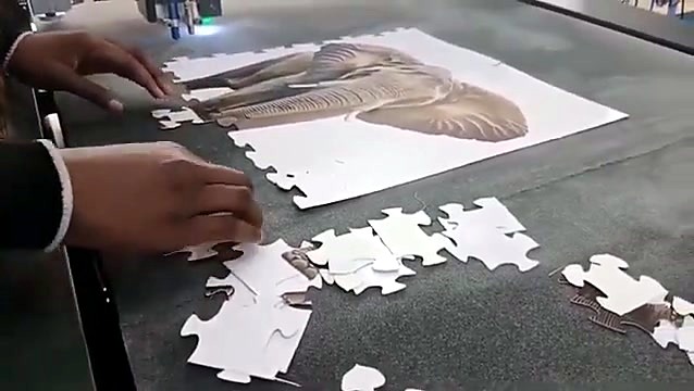 Hands lifting finished elephant jigsaw pieces (SKU ask)