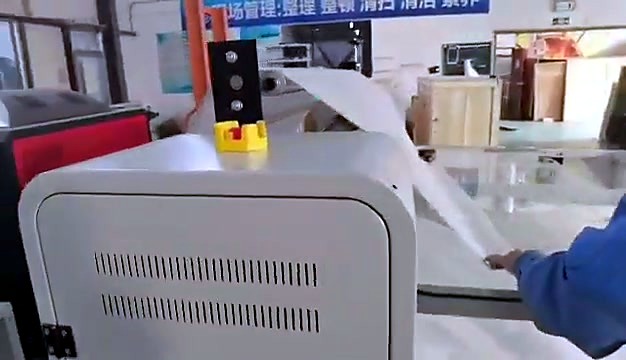 Workers load white fabric on H-ROLLER bed (SKU ask)