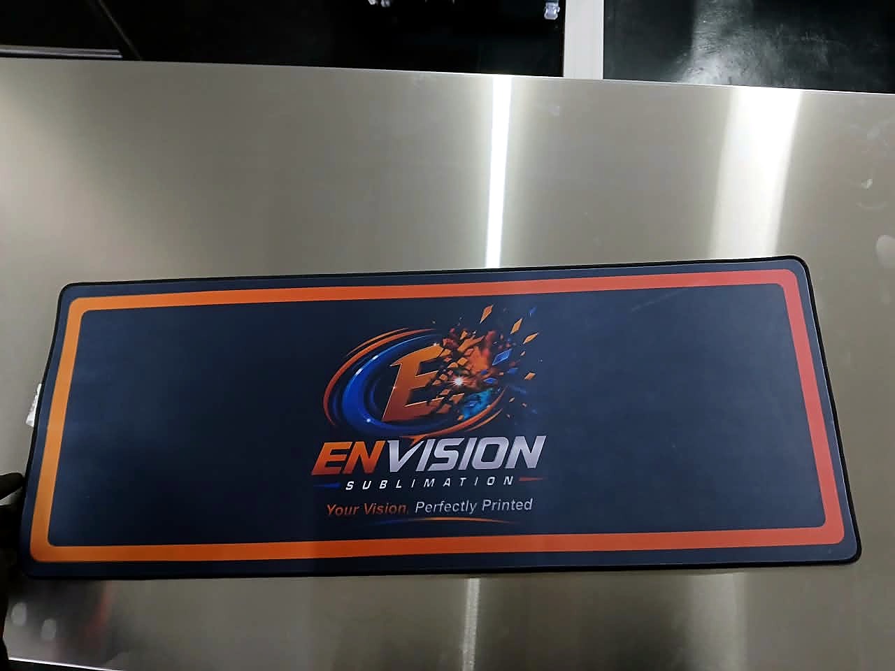 H-ROLLER/1700/OIL9: Envision Sublimation desk-mat print sample on steel table (staff still)