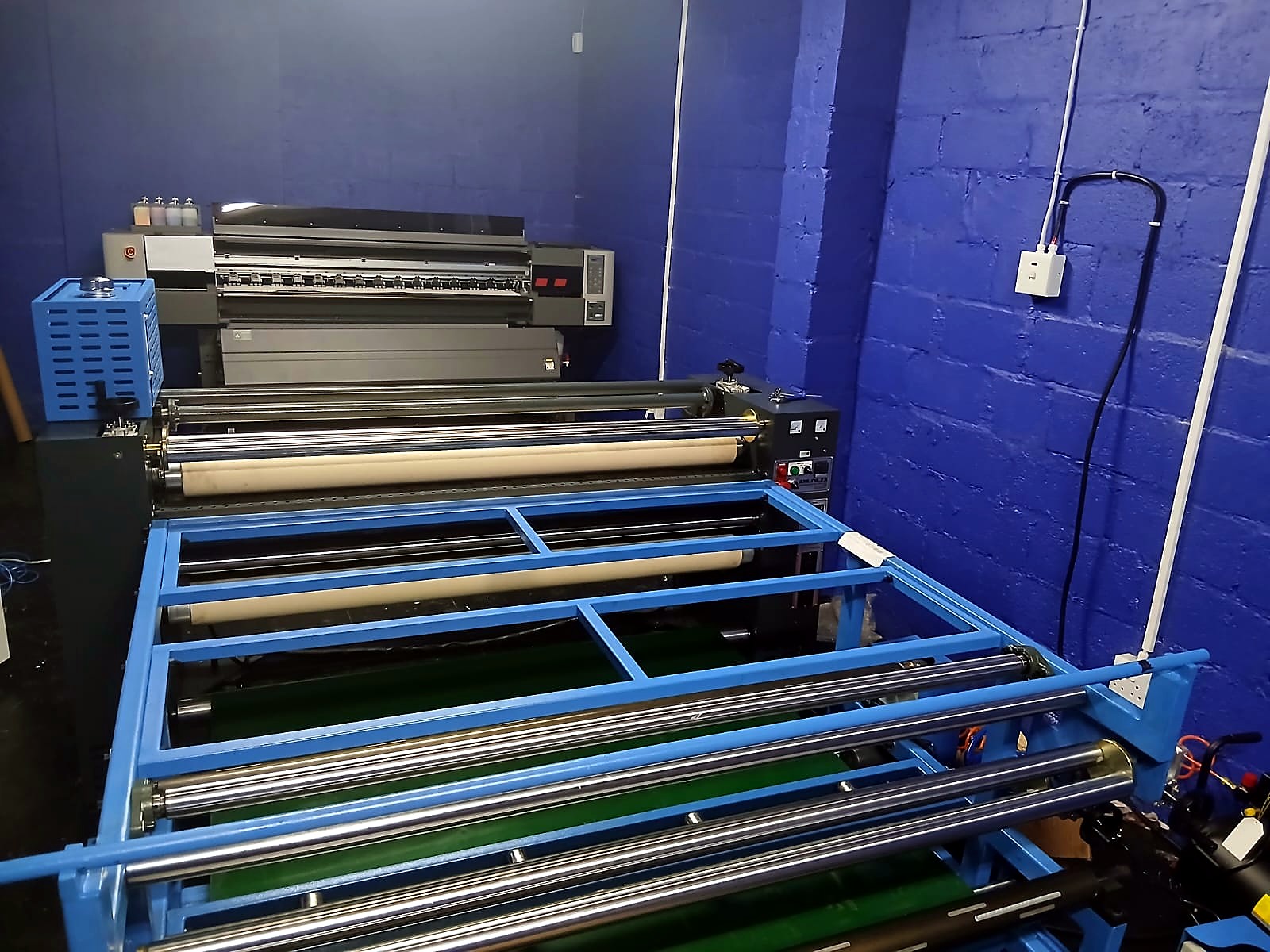 H-ROLLER/1700/OIL9: machine identity — blue frame, chrome/white rollers, green belt, control panel (staff still)