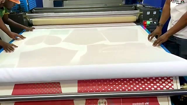 Staff aligning fabric on the H-ROLLER/1700/OIL9 feed table