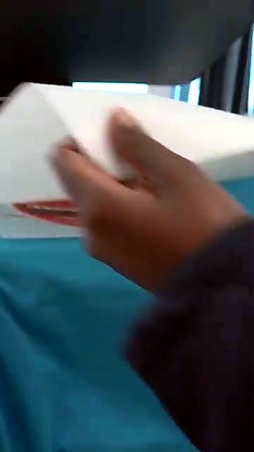 Peeling DTF carrier from turquoise tee (SKU ask)