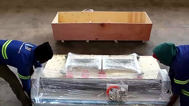 Workers lifting crate lid off RM-1520 (SKU ask)